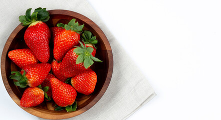 Fresh strawberry in wooden bowl on white background.
