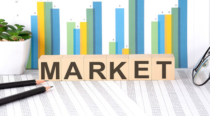 MARKET word written on wood block with chart, glasses and pencils