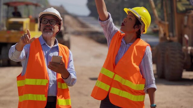 Surveyor builder Engineer road Male and female technician Business Team looking for blueprints in construction sites through blurry on road  construction site. Transport development concept.
