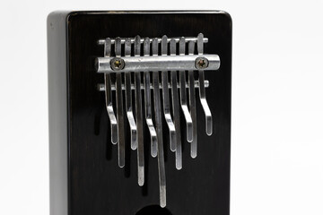 Detail of Kalimba, Mbira african small percussion musical instrument made of dark brown wood on white background close-up