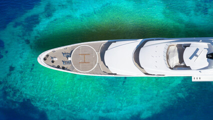 Aerial drone top down photo of luxury exotic yacht nose with wooden deck anchored in paradise...