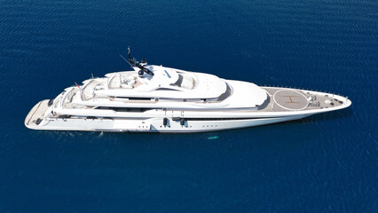 Aerial drone ultra wide photo of luxury yacht with wooden deck and helipad anchored near port of...