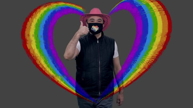 Gay man in pink cowboy hat and mask walks showing thumb up in lgbt heart graphic, alpha channel included in full hd footage