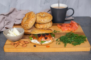 Delicious and healthy homemade meal. Bagel Sandwich with Smoked Salmon, Ikura Salmon Roe and Black Caviar. 