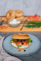 Delicious and healthy homemade meal. Bagel Sandwich with Smoked Salmon, Ikura Salmon Roe and Black Caviar. 