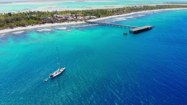 Aerial shot of yacht anchored near tropical island in Pacific