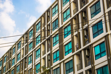 Fototapeta premium Modern condominium window building against blue sky city resident