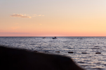 Fototapeta na wymiar Boat sailing at sunset at sea