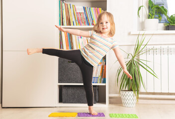 The child trains at home: fitness, yoga, exercises. Distant training with personal trainer, social...