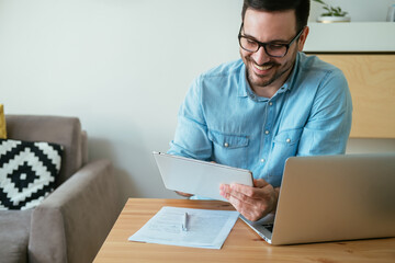 Happy Business Man Using Digital Tablet While Working at Home