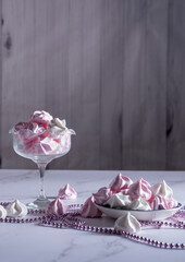 pink and white meringue candies in a vase and on a saucer, sweet still life,