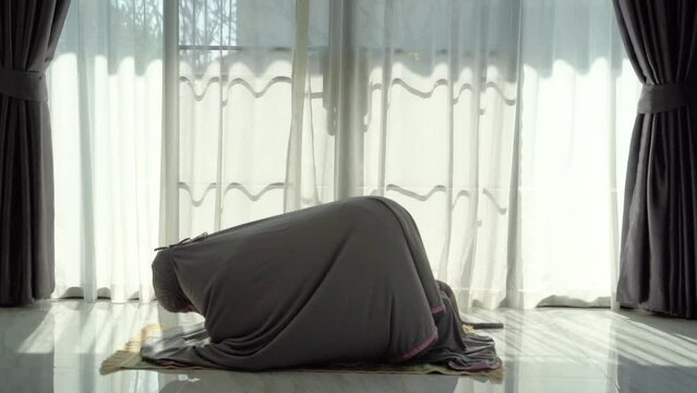 An elderly Muslim man with a gray beard prays at home during the coronavirus pandemic. Covid-19, quarantine concept	