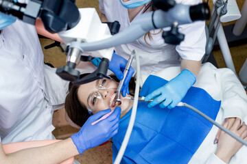 Dentist looking through a microscope at the patient's teeth. Modern progressive dentistry.