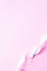 Tampon woman feminine hygiene. Pink ribbon with menstrual tampon on pink background. Menstruation feminine period. Soft tender protection for women critical days.