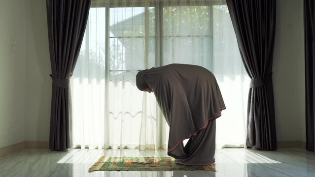 An elderly Muslim man with a gray beard prays at home during the coronavirus pandemic. Covid-19, quarantine concept	