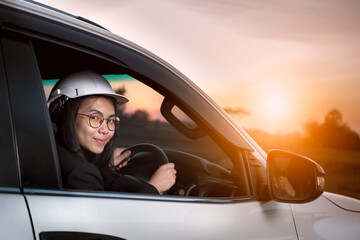 Asian female engineer driving with happy face.