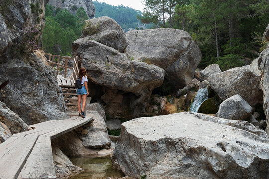Woman contemplating the beautiful rocks and waterfalls on the Parrizal de Beceite route, in Aragon Spain