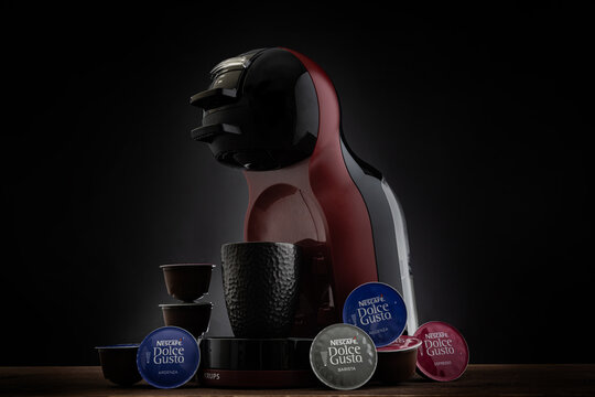 VARNA, BULGARIA - FEBRUARY 4, 2022: Krups Nescafe Dolce Gusto coffee maker machine and capsules on black background.