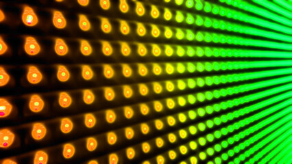 blurred view of abstract bulb lights in yellow, orange, green color. close up of gradient led light in dots pattern for electronic, futuristic, digital concept.