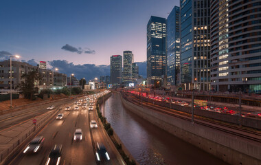 Fototapeta na wymiar Tel Aviv city sunset. Modern glass skyscrapers and automobile Ayalon highway