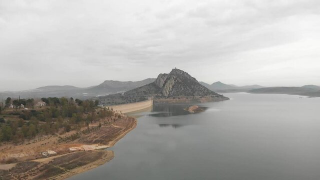 Aerial images showing a huge reservoir from 30 meters high.  In the background a large mountain with a medieval castle on it.  Camera pans to the right showing more reservoir