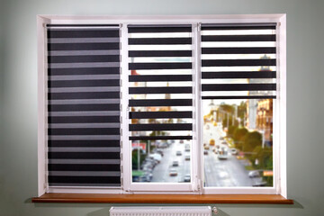 Window roller duo system day and night on woden windowsill with view for very beautiful city