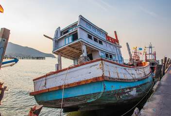 Fototapeta na wymiar A fisherman boat at its berth at a pier in a fishing village