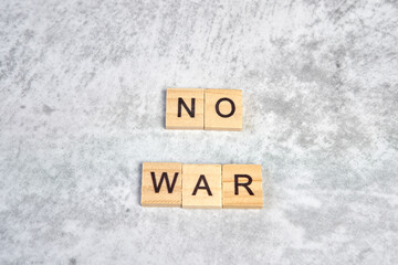 phrase no war is laid out of wooden squares on a gray background. The concept of peace, war in Ukraine