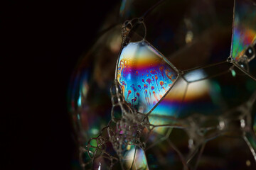 Sunlight refracting through a soap bubble and reflecting a spectrum of colours from the inside...