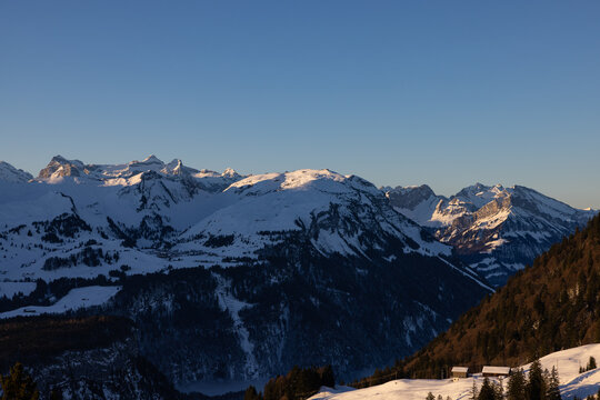 Super panorama of a Swiss mountain ridge that is illuminated by the sun at sunrise. Beautiful wintry and snowy landscape. what a view.