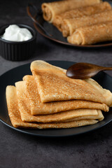 Stack of russian thin pancakes blini with fresh sour cream