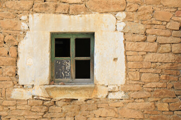 Fototapeta na wymiar ventana de madera vieja verde sin cristales en una pared de piedra pueblo rural 4M0A3249-as22