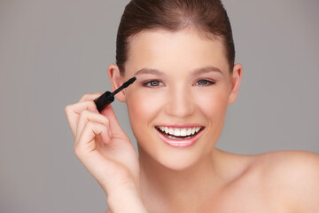 Making sure my eyes stand out. Studio portrait of a beautiful woman applying mascara.