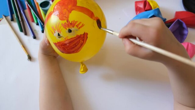 Child coloring yellow balloon. Fun toy as gift for Mothers day, Birthday or Valentines day . Arts  crafts concept. art learning and education
