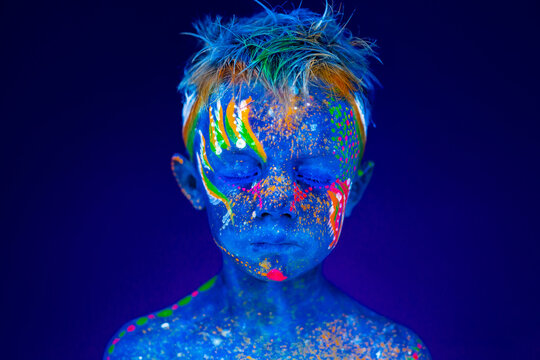 Portrait Of A Neon Child Boy Posing In UV