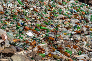 glass bottles of beer, wine, syrups, in an old dump of an abandoned municipality in the Canary Islands on the edge of a large ravine and a tourist road