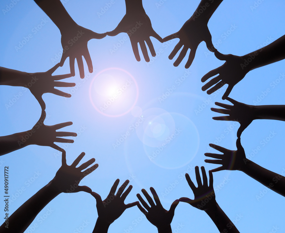 Poster joining together to form one. shot of a group of hands spread out together in a circle.