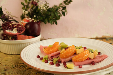 Pancakes. Pink sweet dough with fruits and honey. Tangerines, kiwi, pomegranate seeds. Floral background. Delicious breakfast at home or in a cafe. Selective focus. Shrovetide menu. carnival baking