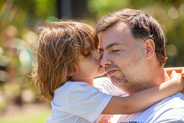 little girl hugging happy father in the park