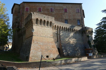 Sforza Fortress in Dozza, the medieval building with ravines sorrouded by circular bastions and a moat with a green lawn inside
