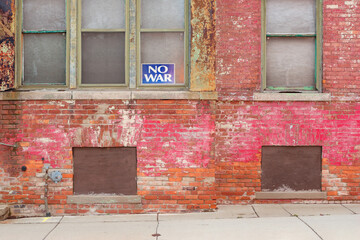 No War sign in the window of an old brick building