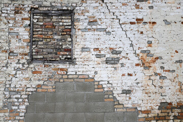 Old crumbling brick wall with windows