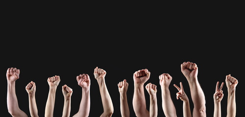 Clenched fists raised in protest on black