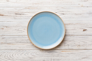 Top view of empty blue plate on wooden background. Empty space for your design