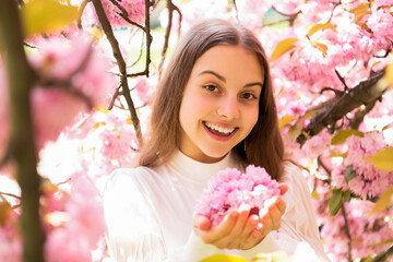 Fototapeta premium cheerful kid at sakura flower bloom in spring