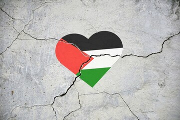 The symbol of the national flag of Palestine in the form of a heart on a cracked concrete wall.