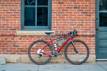 Fototapeta na wymiar gravel bike with lightweight carbon frame and wireless drivetrain against old brick building wall