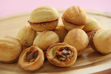 cookies in the form of nuts with condensed milk on a wooden stand