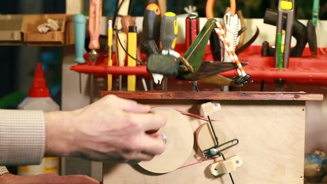 grasshopper toy close-up, master turns the handle of the automaton mechanism