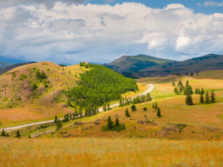 Naklejka premium Picturesque summer mountain landscape with road through the pass. Turn on the asphalt mountain highway. Chuysky tract and a view of the North Chuysky Mountain range in the Altai, Siberia, Russia.